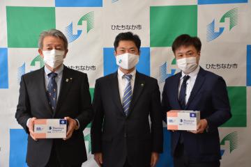 大谷明市長(中央)からマスクを受け取った川崎誠会長(左)ら=ひたちなか市役所
