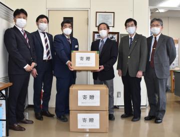 マスクの寄贈を受ける常陸太田市医師会の小林肇会長(右から3人目)=同市中城町