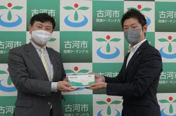 古河市にマスク1万枚を寄贈したSSPの菅井里輝社長(右)=同市役所総和庁舎