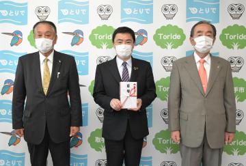 藤井信吾取手市長(中央)に300万円を寄付した根本健樹社長(右)と大竹光社長=同市役所