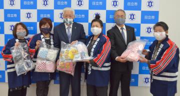 日立市の小川春樹市長(左から3人目)に手作り布マスクを寄贈する市女性防火クラブ連絡協議会の橋本弘子会長(同4人目)=市役所