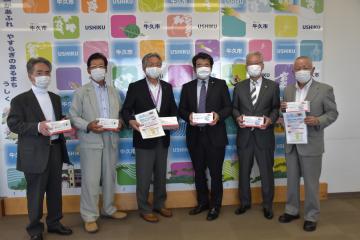 マスクと消毒液を寄贈した3社・団体の関係者と根本洋治市長(左から3人目)=牛久市中央