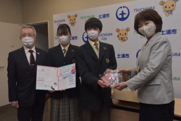 安藤真理子市長(右)に手作りマスクを手渡す土浦日大高の生徒ら=土浦市役所
