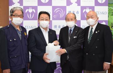 原浩道市長(左から2人目)に消毒液を手渡す室谷洋三会長(同3人目)=潮来市役所