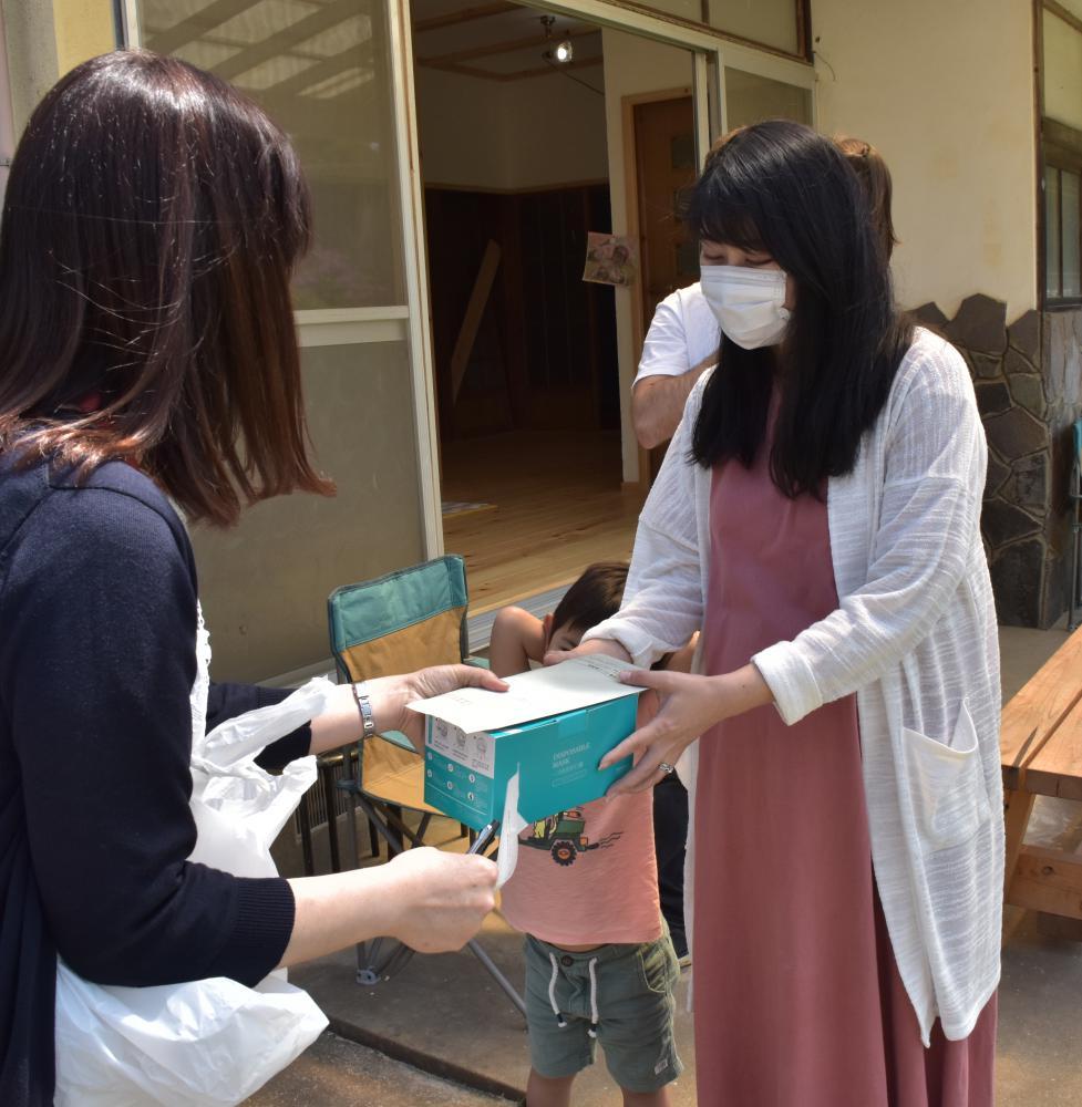 保健師(左)からマスクを受け取る妊婦の川崎彩未さん=常陸太田市亀作町