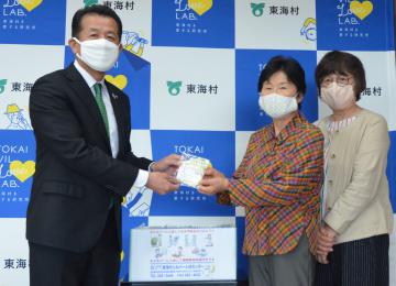 山田修村長に手作りの布マスクを手渡す高畑則子さんと本田章子さん(左から)=東海村役場