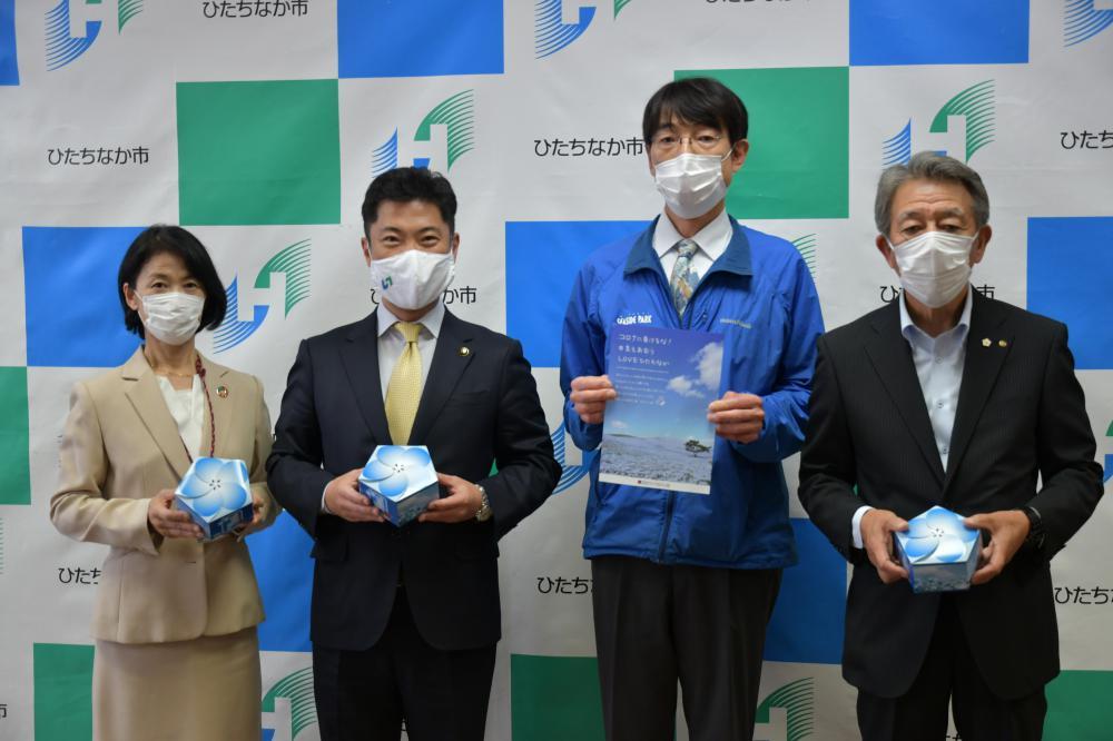 大谷明市長(左から2人目)にネモフィラクッキーを手渡した安達明彦ひたち海浜公園管理センター長(同3人目)ら=ひたちなか市役所