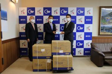 先崎光市長(中央)にマスクを寄贈する紙野康久社長(右)=那珂市役所