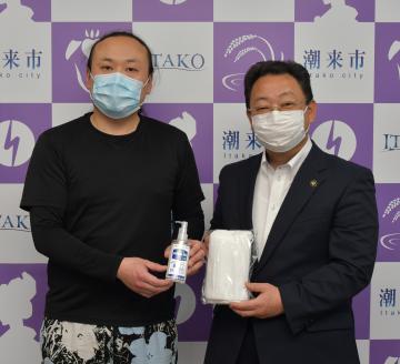 マスクと消毒液を寄贈した兼平和樹さん(左)と原浩道潮来市長=潮来市役所