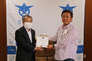 茨城町にマスク1万枚を寄贈した廣澤一浩さん(右)=同町役場