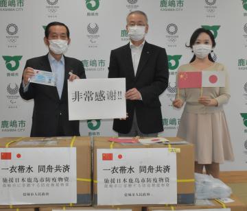 中国・塩城市から届いたマスクに対し、謝意を示す鹿嶋市の錦織孝一市長(左)と市日中友好協会の千葉功会長(中央)=鹿嶋市役所