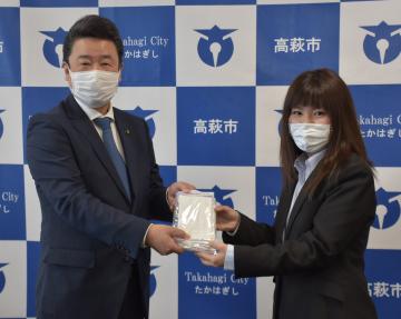 手作りマスクを大部勝規高萩市長(左)に手渡す吉田夏奈さん=同市役所