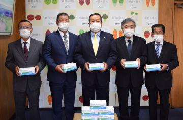 マスクを寄贈した藤枝洋二会長(左から2人目)=鉾田市役所