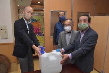 施設側から桜井昇区長(右)らに除菌水が手渡された=土浦市高岡