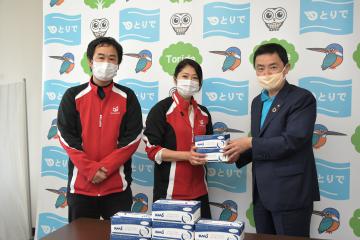 藤井信吾取手市長(右)にマスクを手渡すビッグワン・コバヤシの小松由紀子取締役管理本部長(中)ら=同市役所