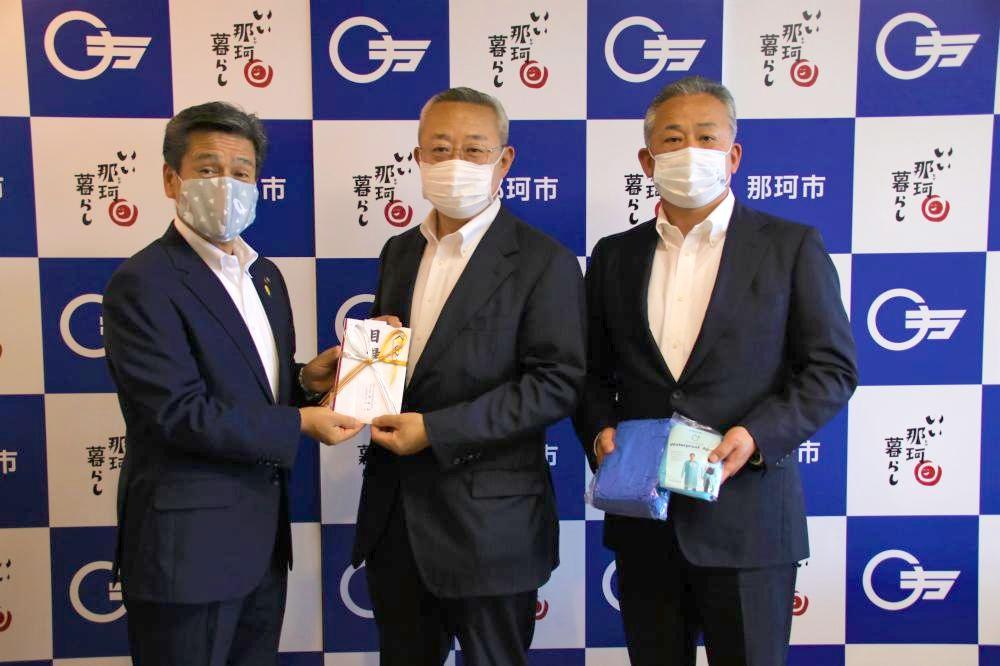 那珂市の先崎光市長(左)に目録を手渡すマルトの安島浩社長(中央)と安島誠専務=那珂市役所