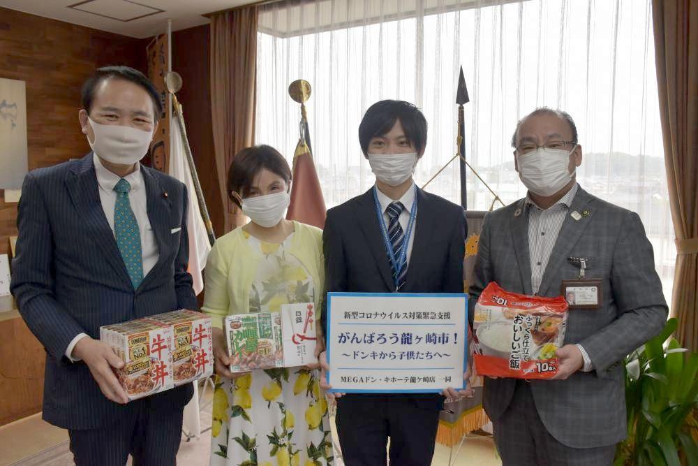 笠井広子代表(左から2人目)に食料品などを寄贈した千葉充店長(同3人目)ら=龍ケ崎市役所