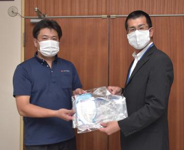 フェースガードなどを寄贈した光和の土田幸司さんと秋山小学校の関根紀夫校長(左から)=高萩市島名
