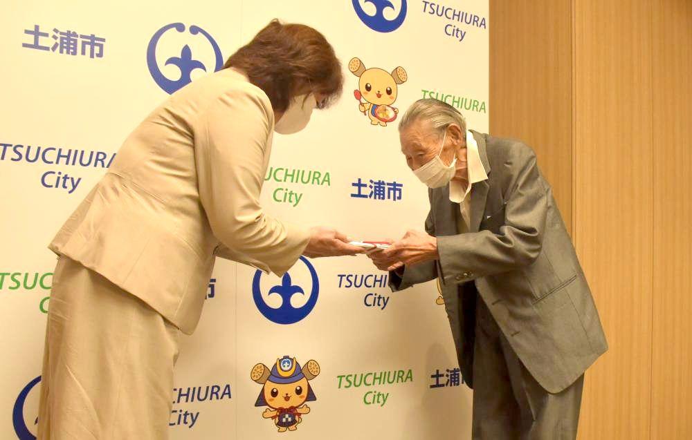 菊田正夫さん(右)から安藤真理子市長に寄付金が手渡された=土浦市役所