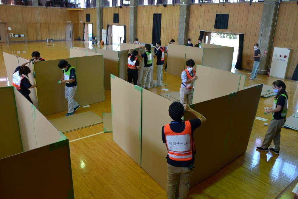 避難所運営訓練で間仕切りを組み立てる茨城町の職員=同町小堤