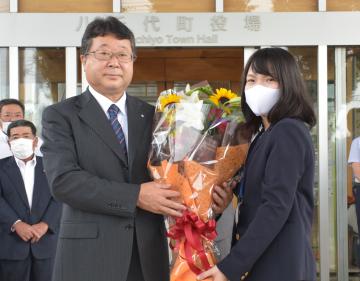 職員から花束を受け取る野村勇町長(左)=八千代町役場