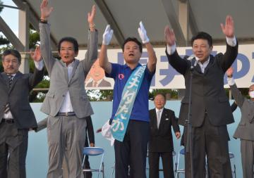 無投票で初当選し、万歳する国井豊氏(中央)=大洗町港中央
