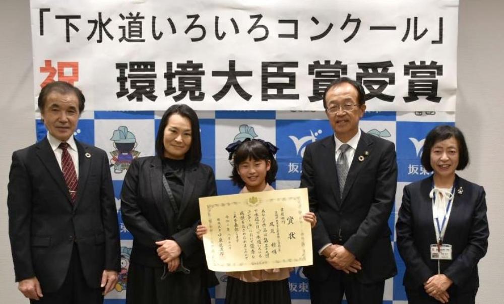 環境大臣賞を受賞し、木村敏文市長(右から2人目)から表彰状を受け取った風見檀さん(中央)=坂東市役所