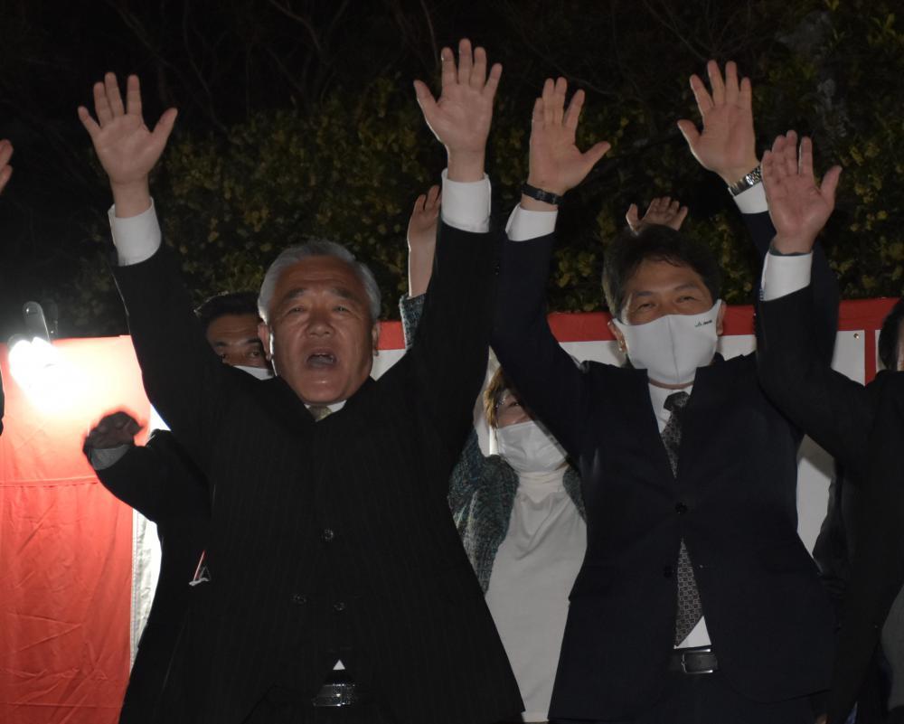 筑西市長選で当選確実の知らせを受け万歳する須藤茂氏(左)ら=11日午後10時3分、筑西市二木成