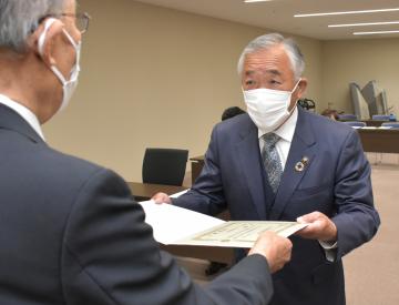 筑西市選挙管理委員会の大木安史委員長から当選証書を手渡される須藤茂氏(右)=同市役所