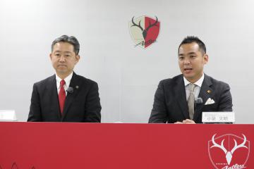協定締結式でオンライン会見に臨む行方市の鈴木周也市長(左)と鹿島アントラーズの小泉文明社長=鹿嶋市神向寺(クラブ提供)