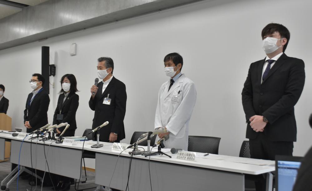 水戸市の高齢者施設で起きた誤接種について記者会見で謝罪する秋葉宗志副市長(中央)ら=19日午前、市役所