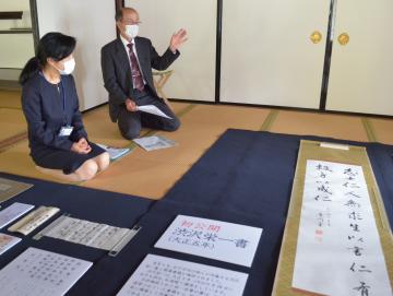 書と書簡について説明する所蔵者の後藤卓巳さん(右)と研究員の小圷のり子さん=水戸市三の丸