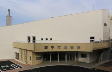 「壁アート」が描かれる市民会館。傾斜があるクリーム色の正面部分に描かれる=取手市東