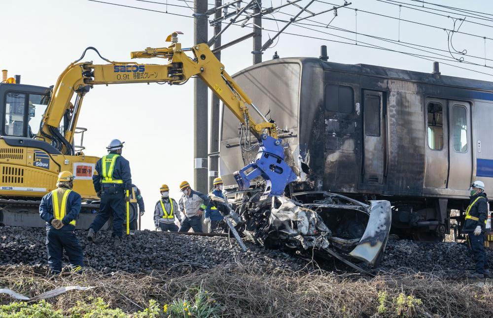 土浦市木田余の線路内で、JR常磐線の電車と衝突し炎上した乗用車=3月26日(住民提供)