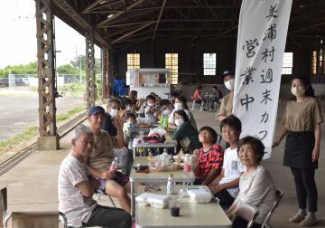 美浦村初の地域おこし協力隊として着任した村川さん夫婦(右)が、倉庫跡でキッチンカーによるカフェを始めた=美浦村大山