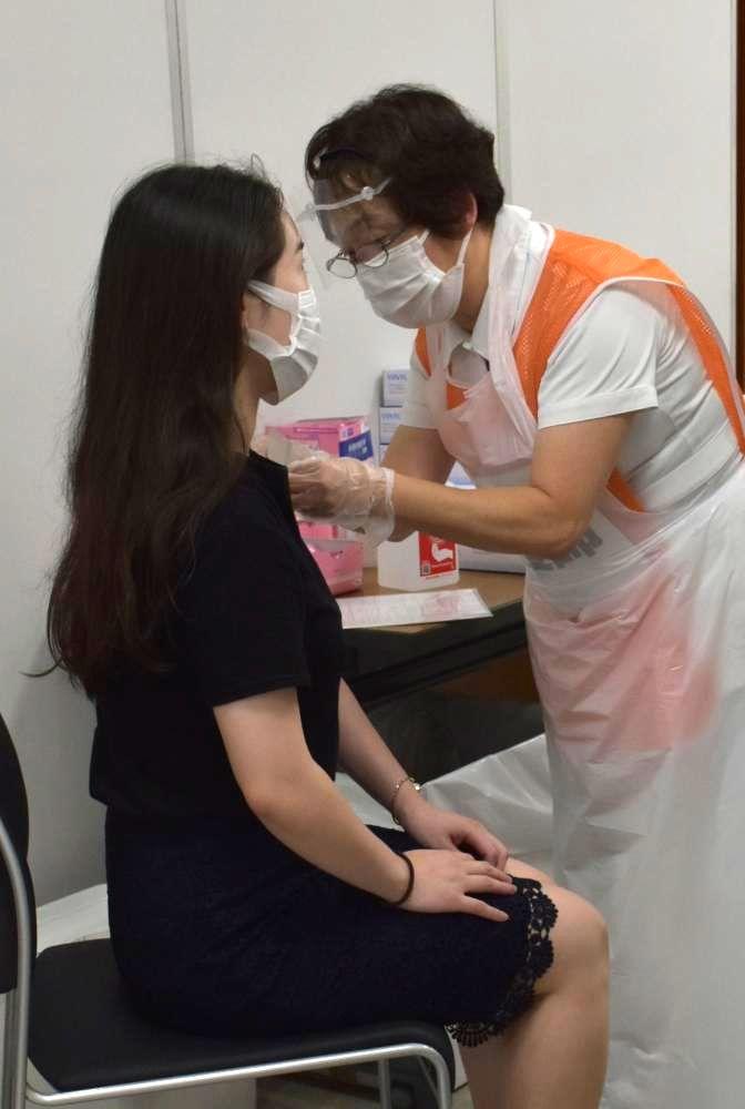 新型コロナウイルスワクチンを打つ常陽銀行の従業員(左)=水戸市南町
