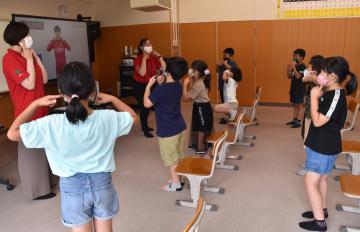 鹿島アントラーズの選手たちが登場する動画(左奥)で英語を学ぶ児童たち=鹿嶋市須賀の市立豊郷小