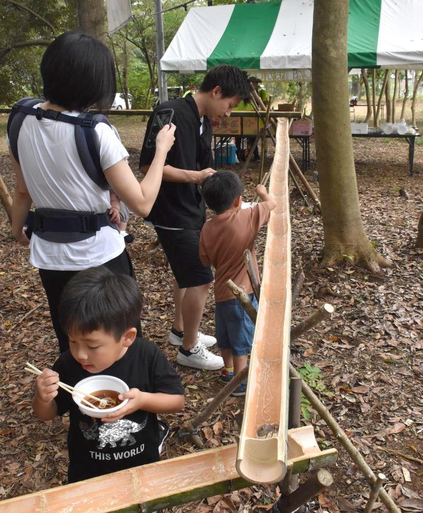 流しそうめんを楽しむ家族連れ=鹿嶋市宮中