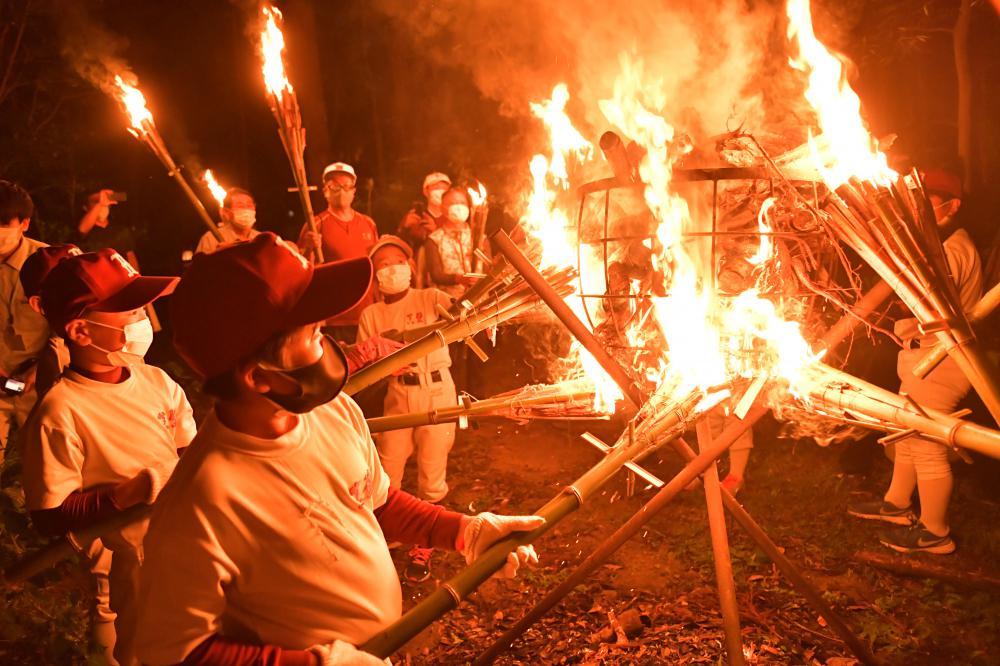 たいまつに移した火を山の入り口まで運ぶ「かったて祭り」の参加者=31日午後6時半ごろ、桜川市真壁町山尾