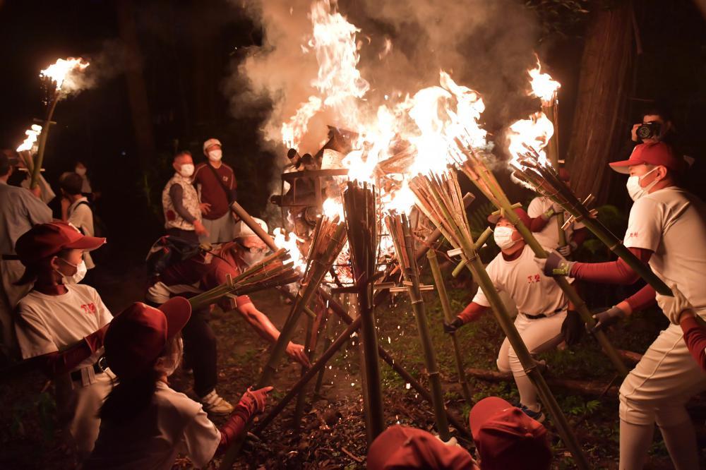 たいまつに移した火を山の入り口まで運ぶ「かったて祭り」の参加者=31日午後6時半ごろ、桜川市真壁町山尾