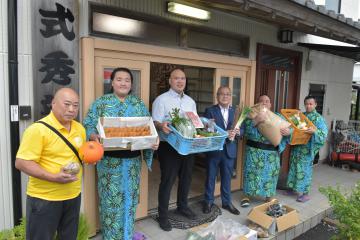 式秀親方(左から3人目)に食材を差し入れる中山一生市長(同4人目)=龍ケ崎市佐貫の式秀部屋