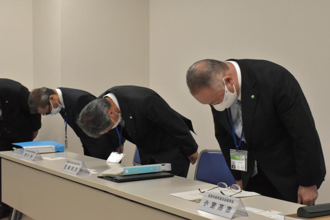 筑西市教育委員会の職員の逮捕をめぐり、臨時会見で頭を下げ謝罪する小室高志教育長(右)ら=同市役所