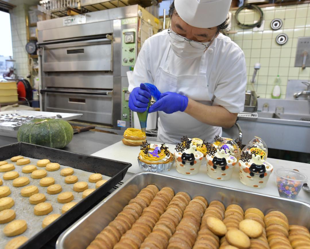 江戸崎かぼちゃを使ったペーストクリームでハロウィーン用ケーキを仕上げる職人=土浦市桜町、高松美鈴撮影
