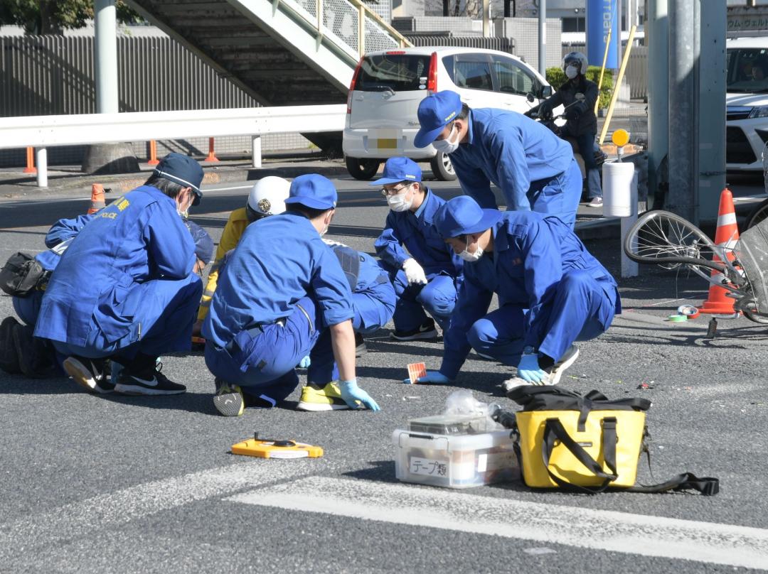 自転車の高校生がはねられた現場の交差点を実況見分する捜査員=12日午前11時52分、古河市東4丁目