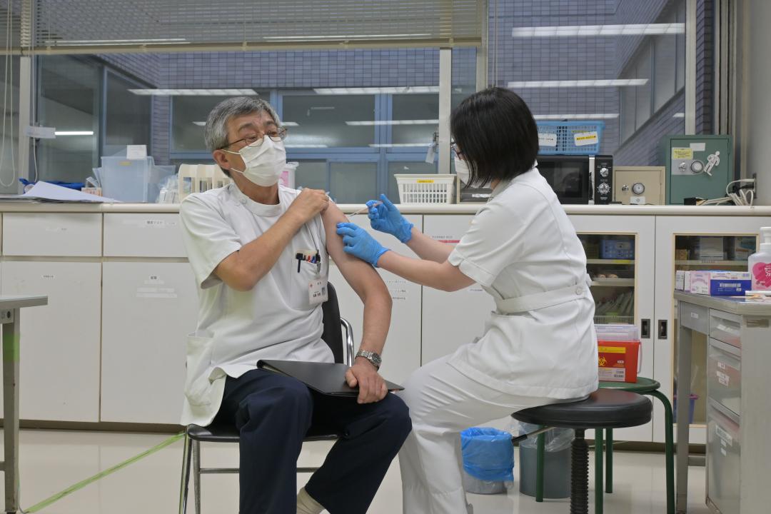 3回目の新型コロナウイルスワクチン接種を受ける水戸赤十字病院の佐藤宏喜院長(左)=水戸市三の丸