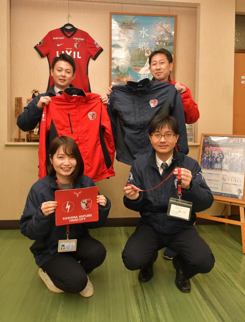 鹿島アントラーズが行政職員向けに販売したオリジナルグッズを持つ潮来市職員=同市辻の市役所