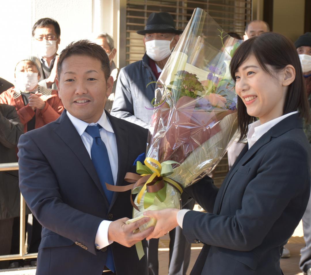 職員から花束を受け取る萩原勇市長(左)=龍ケ崎市役所
