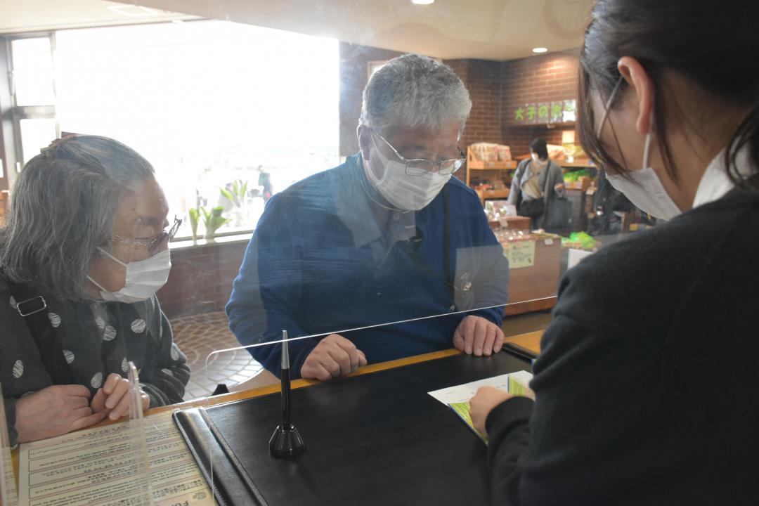 大子温泉やみぞホテルのフロントでいば旅あんしん割の利用手続きを行う宿泊客=大子町矢田