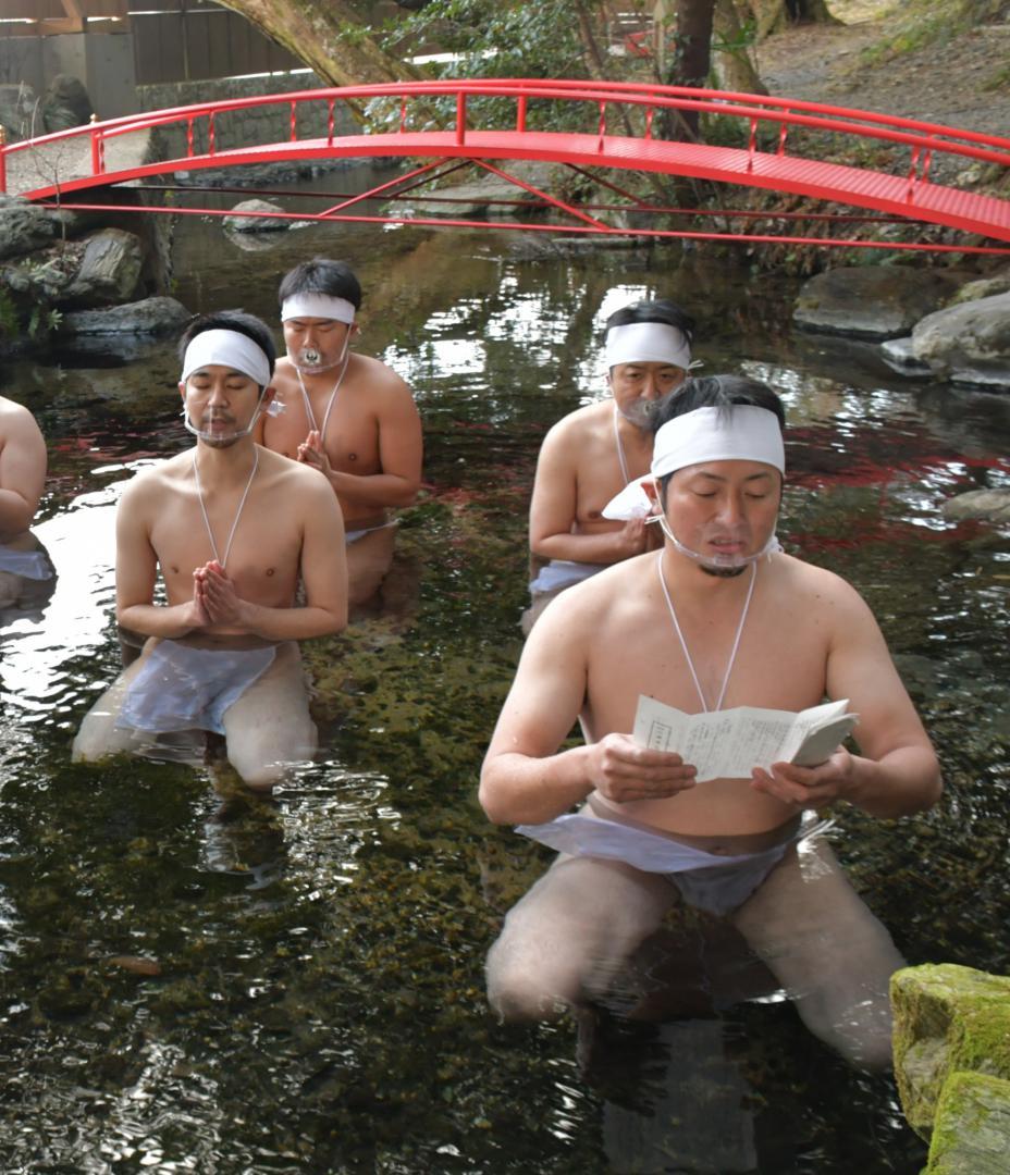 境内の泉に入り、祝詞を上げる神職たち＝日立市水木町の泉神社