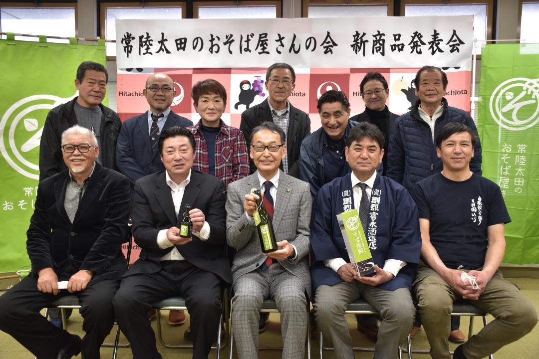 おそば屋さんの会の会員が宮田達夫市長(前列中央)に新商品のそば焼酎の完成を報告した=常陸太田市金井町
